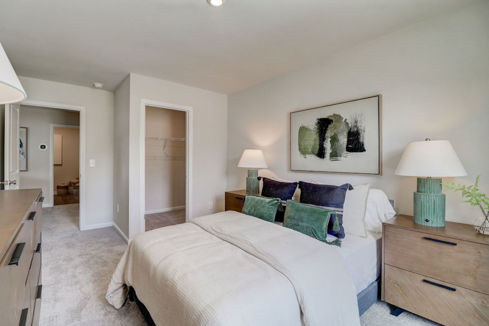 A bedroom with a bed and lamps.