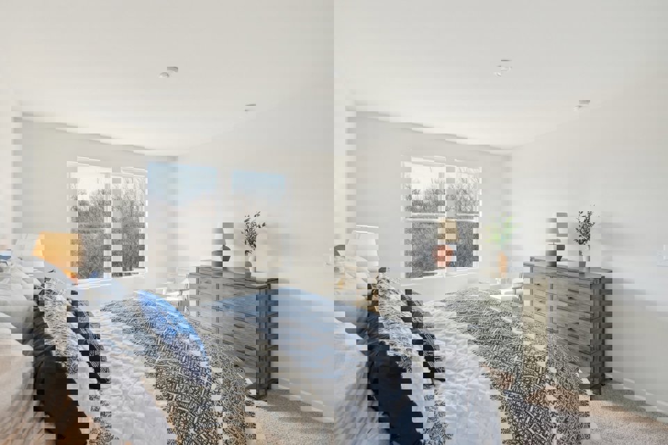 A bedroom with a bed and dresser.