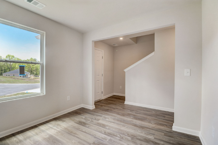 A room with a wood floor and a window.