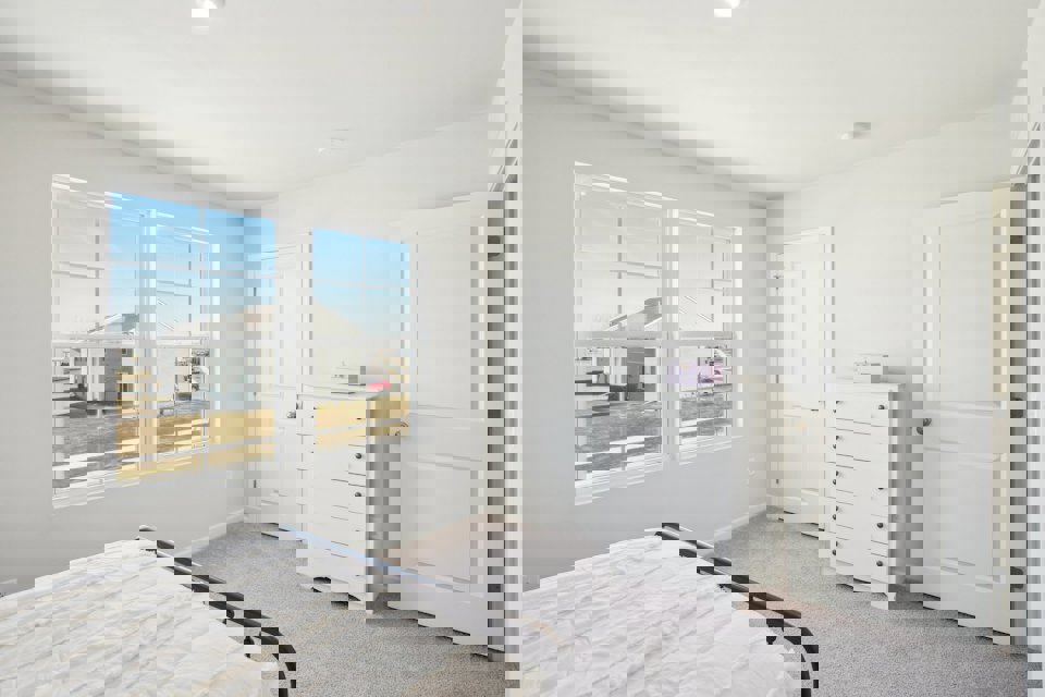 A bedroom with a bed and a window.