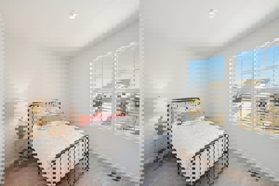 A bedroom with a bed and a window.