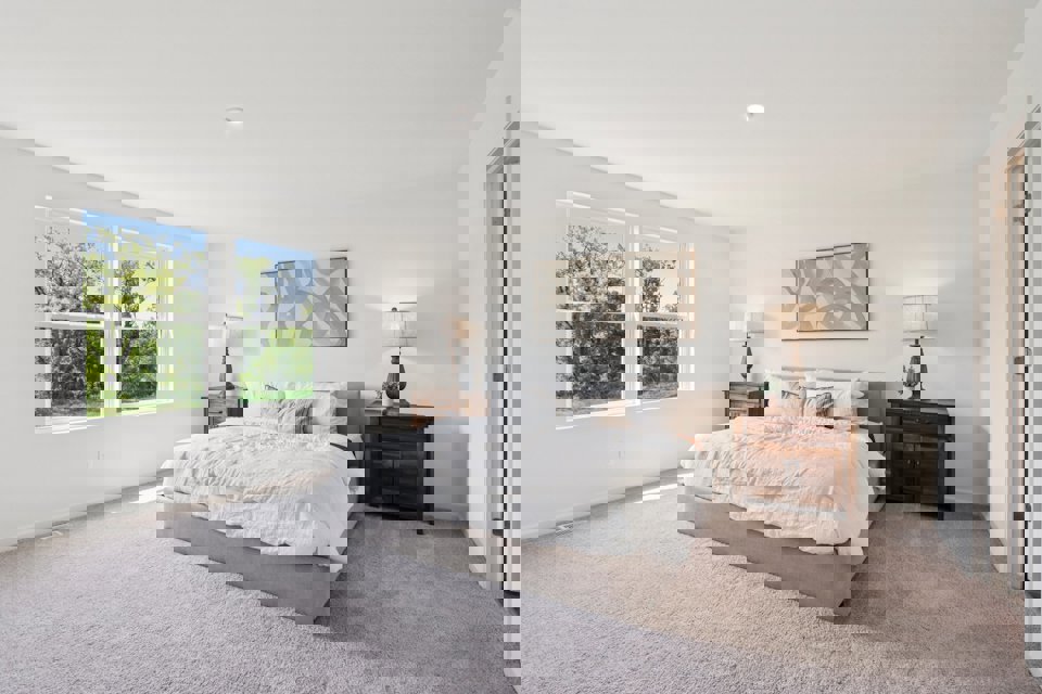 A bedroom with a bed and lamps.