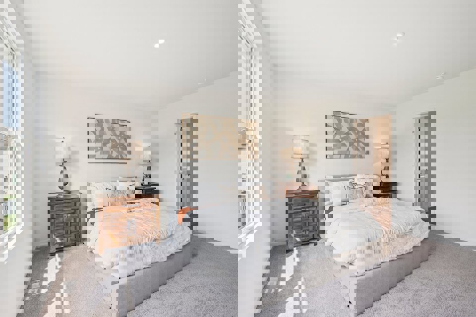 A bedroom with a bed and lamps.