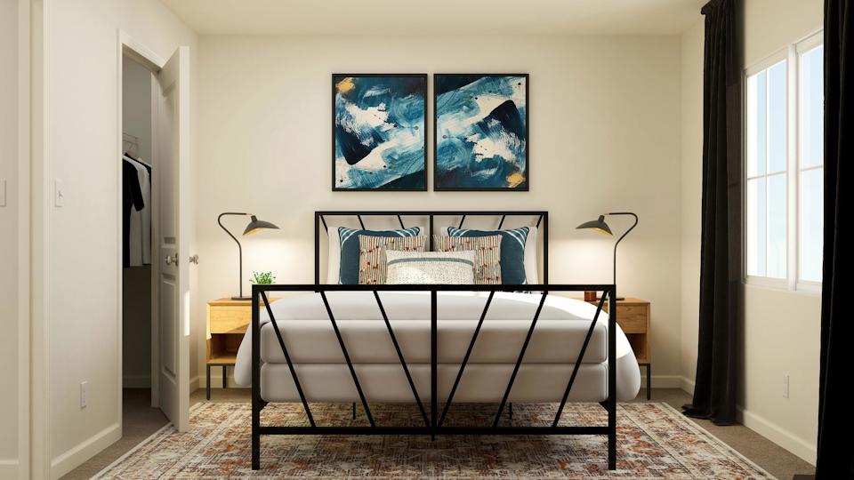 A room with a table and a lamp and a painting on the wall.