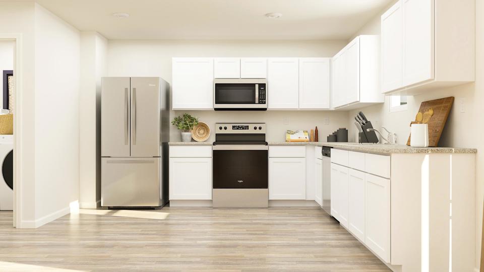 A kitchen with white cabinets.