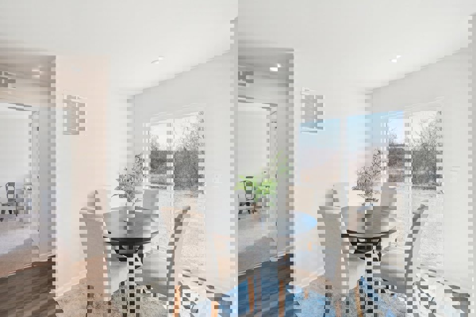 A dining room with a table and chairs.