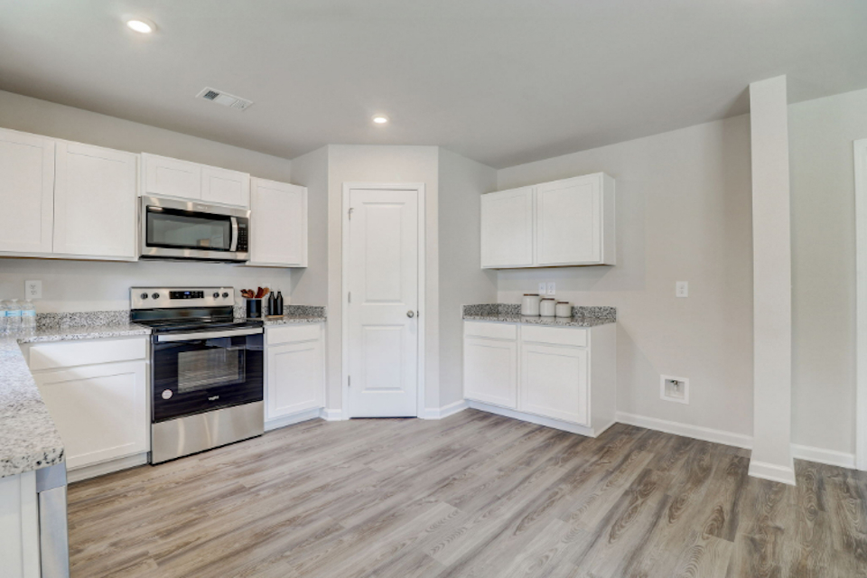 A kitchen with white cabinets.