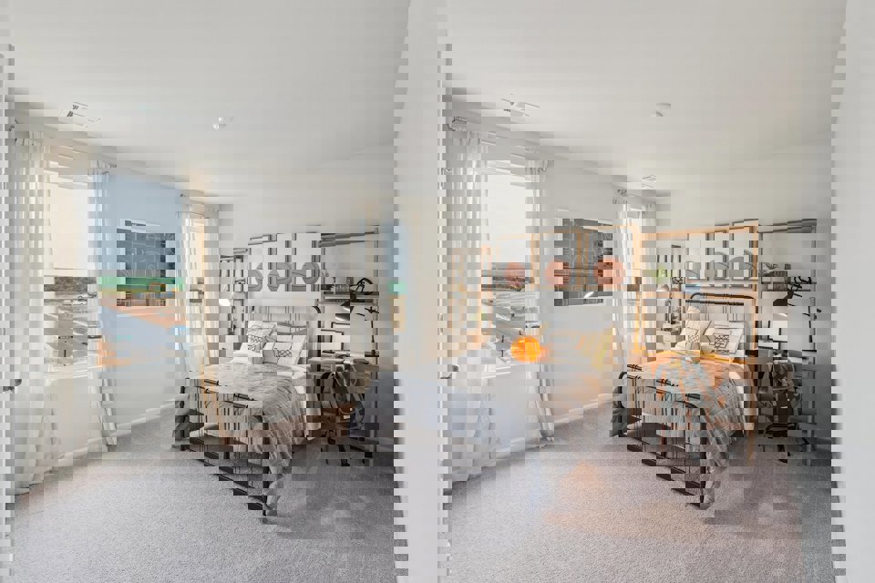 A bedroom with a bed and a chair.