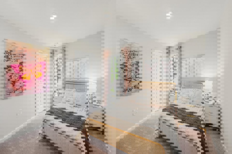 A bedroom with a bed and a lamp.