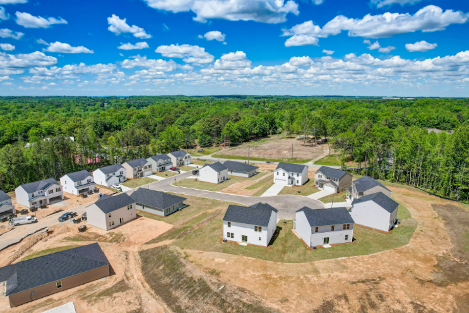 A group of houses in a wooded area.