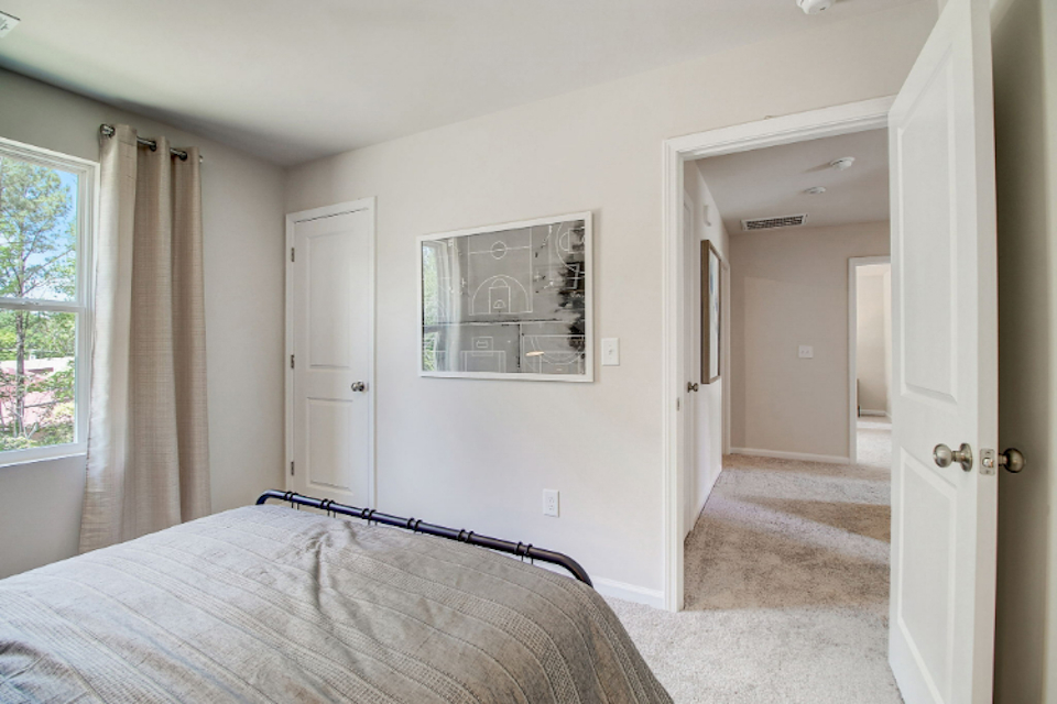A bedroom with a large mirror.