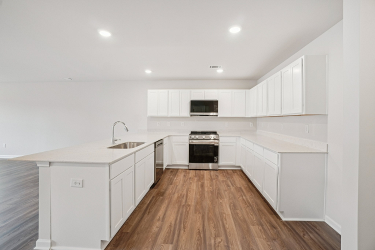 A kitchen with white cabinets.