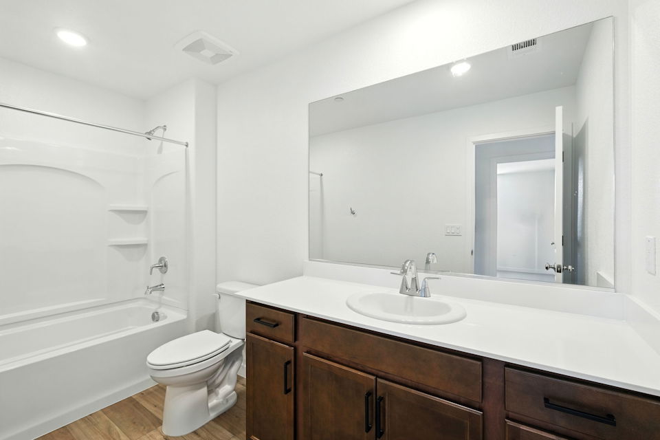 A bathroom with a tub sink and toilet.