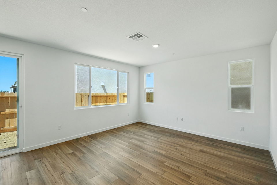 A room with a wood floor and windows.