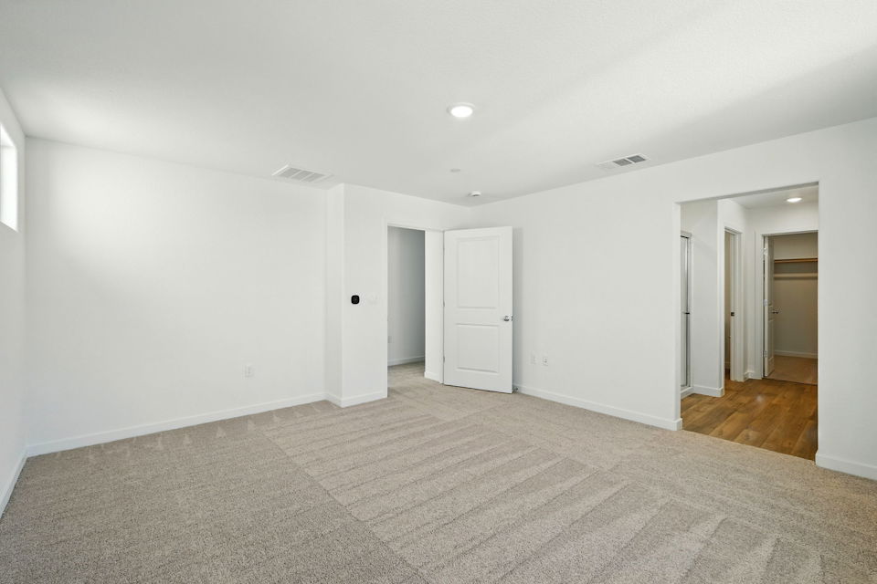 A long hallway with white doors.
