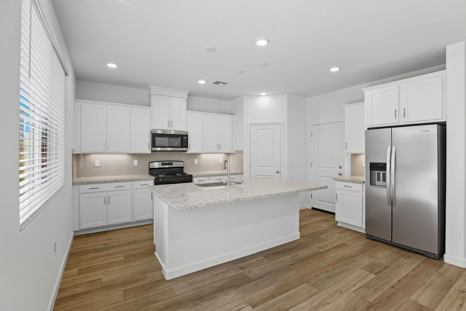 A kitchen with white cabinets.