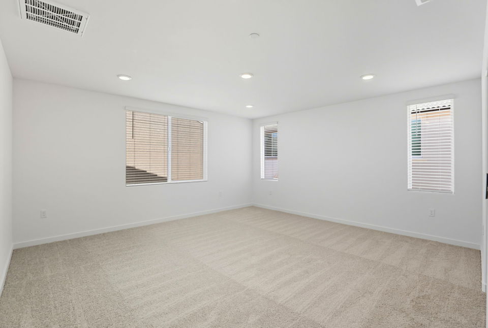 A room with a carpet and windows.