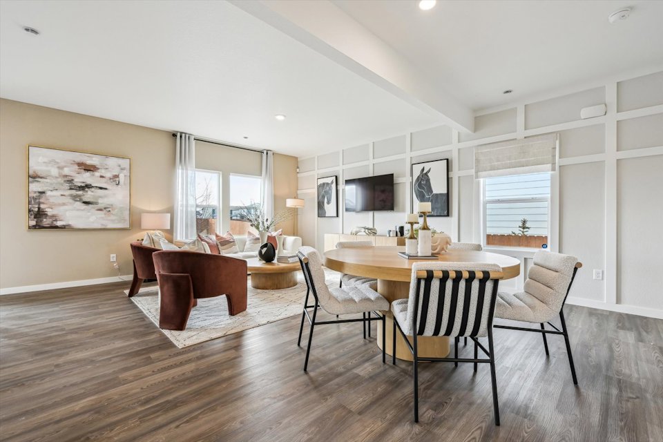 A large dining room with a wood floor.